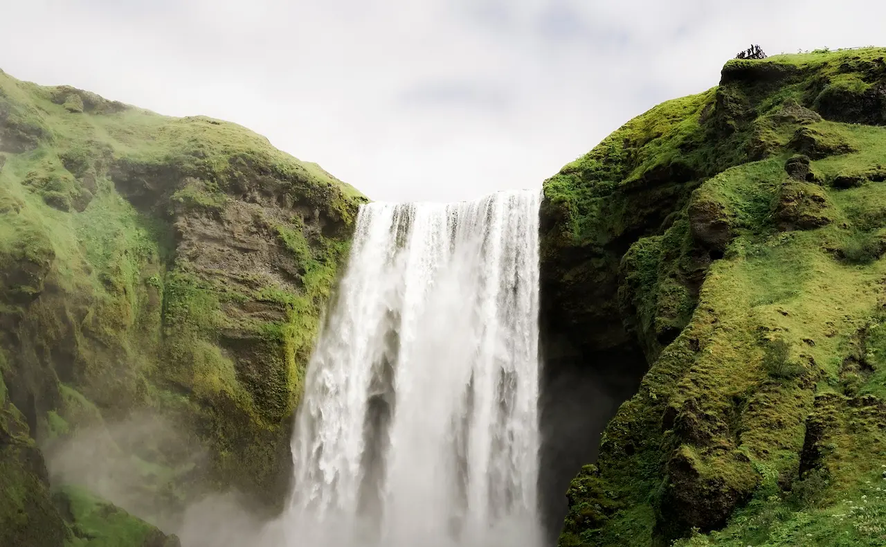 Une cascade entourée de relief couvert de verdure