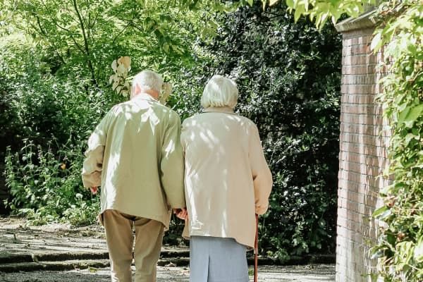 Deux personnes agées de dos se tenant la main