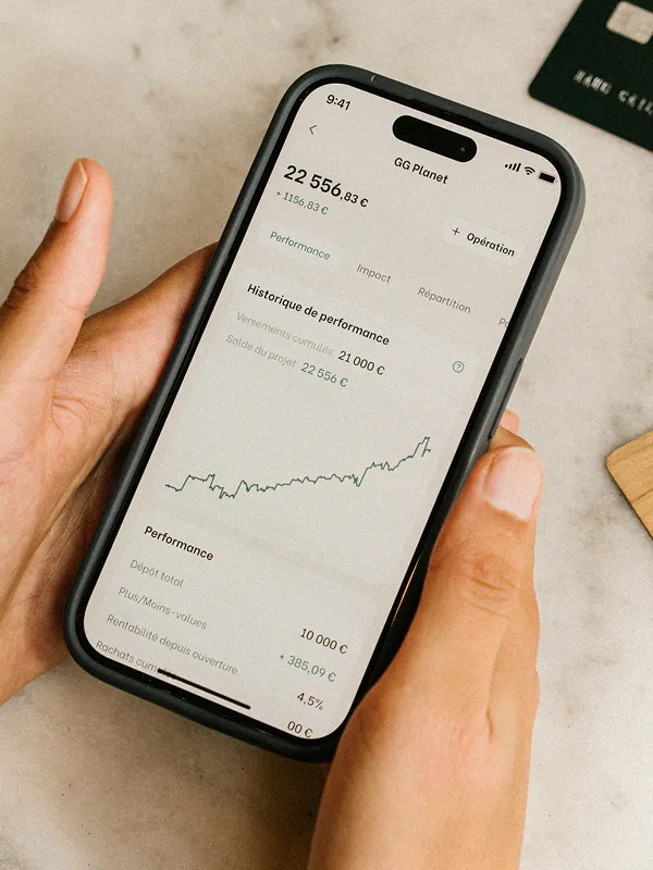 Un téléphone tenu montrant la page investissement de l'app