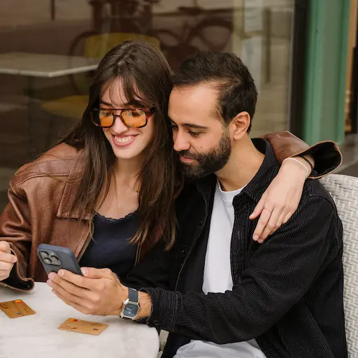Deux personnes en terrasse regardant leur téléphone