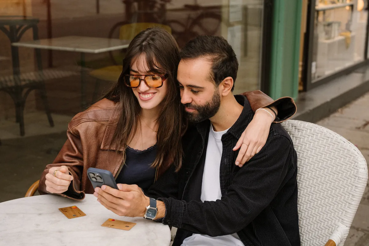 Deux personnes en terrasse regardant leur téléphone
