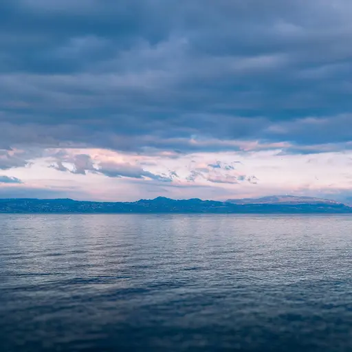 Mer calme avec des montagnes a l'horizon